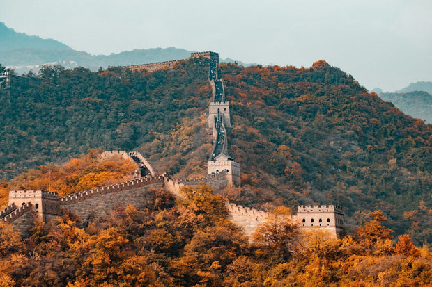 The Great Wall of China winding across green mountain ridges